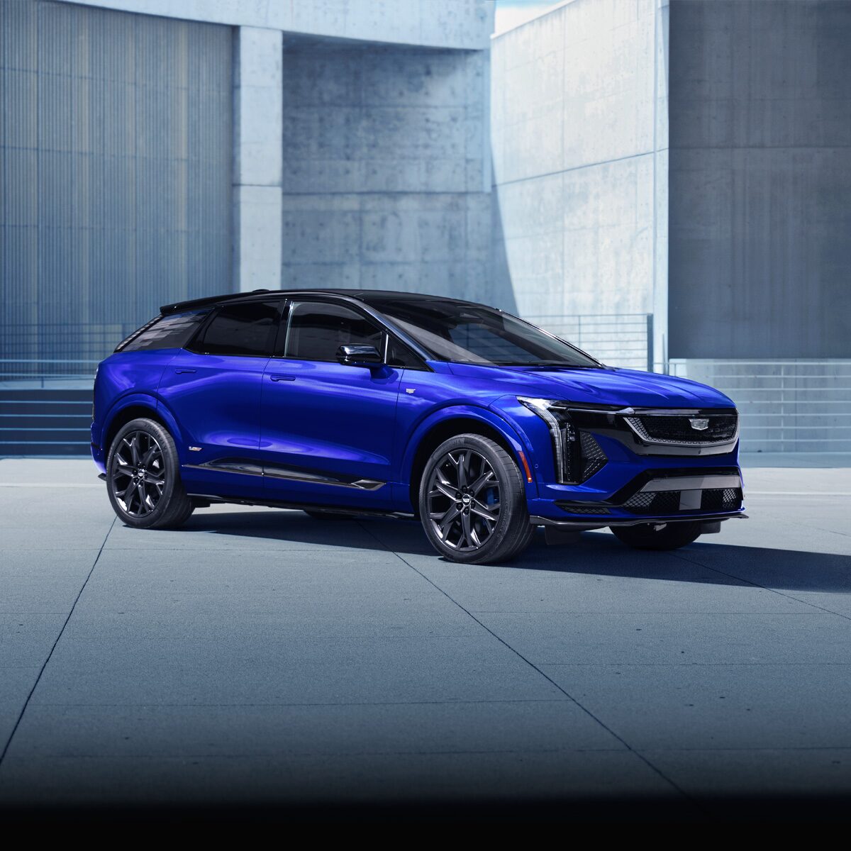 Three-quarters Passenger View of a Blue OPTIQ-V Parked Outside a Concrete Building