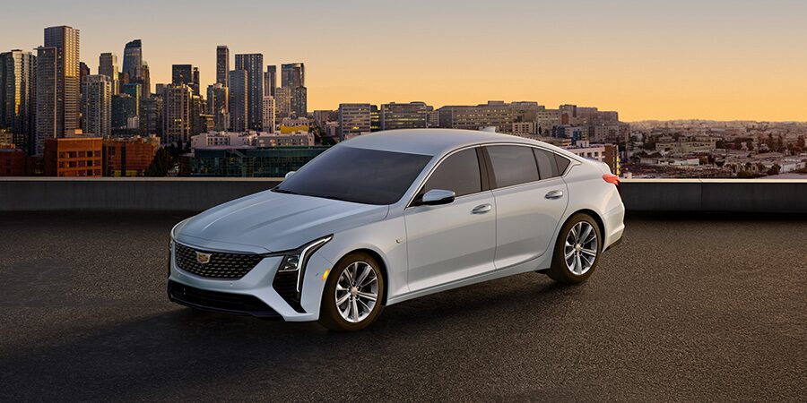 Three Quarters View of a White Cadillac Vehicle on a Rooftop with a City Skyline Seen in the Distance