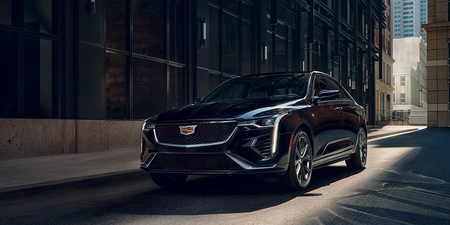 Three Quarters View of a Black Cadillac Vehicle Parked Next to a Building