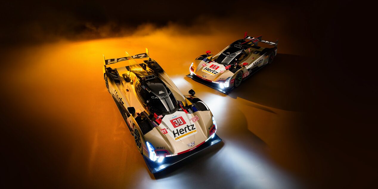 Three of the Cadillac Racing Team Members Smiling and Throwing Up a Number 1 and Their Fists Celebrating a Win