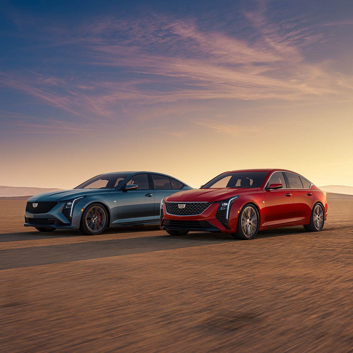 Two Cadillac CT5 Vehicles Parked Next to Each Other in the Open Desert Under a Beautiful Sunset