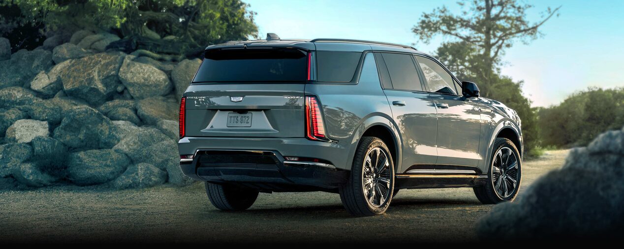 Rear Three-quarter View of the Cadillac ESCALADE IQL Long-Range EV Parked near a Rocky Trail