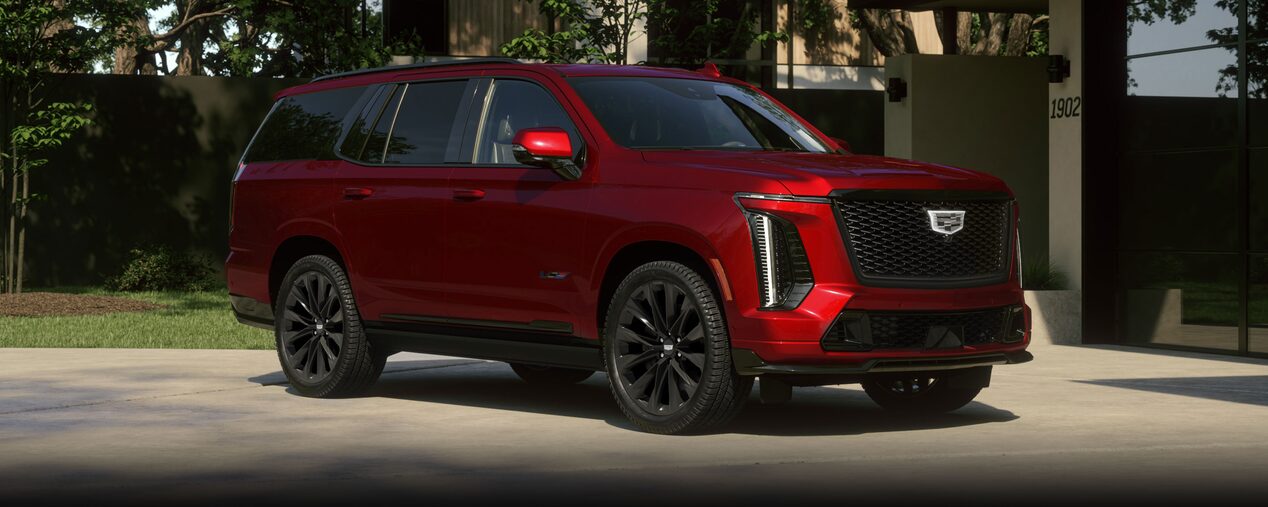 Three-quarter View of a Red Cadillac Escalade-V Passenger Side Parked Outside of a Modern Home