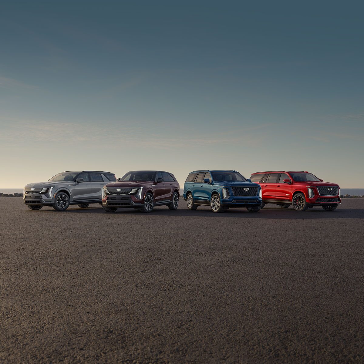 A Front View of Four Cadillac Escalades Parked in the Open Desert Under a Blue Sky