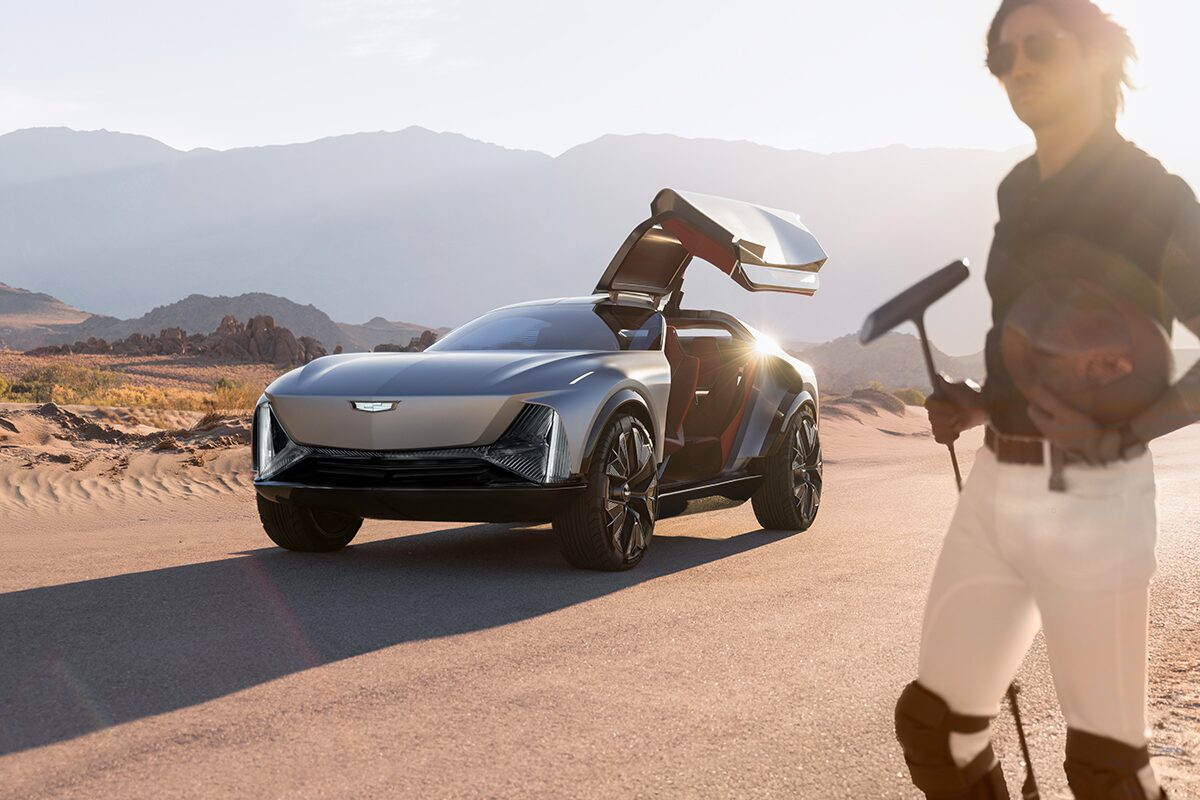 The Sun Shining Off the Cadillac Elevated Velocity Concept Vehicle with the Driver Butterfly Door Open onto a Croquet Player in the Desert