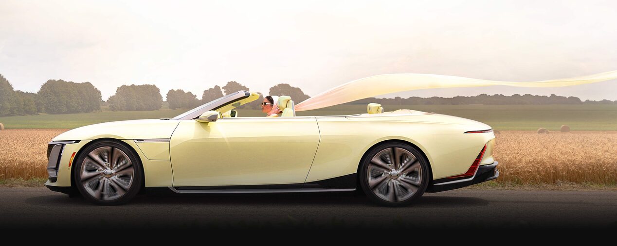 A Woman with a Flowing Scarf Driving the Cadillac Sollei Concept Convertible in the Country