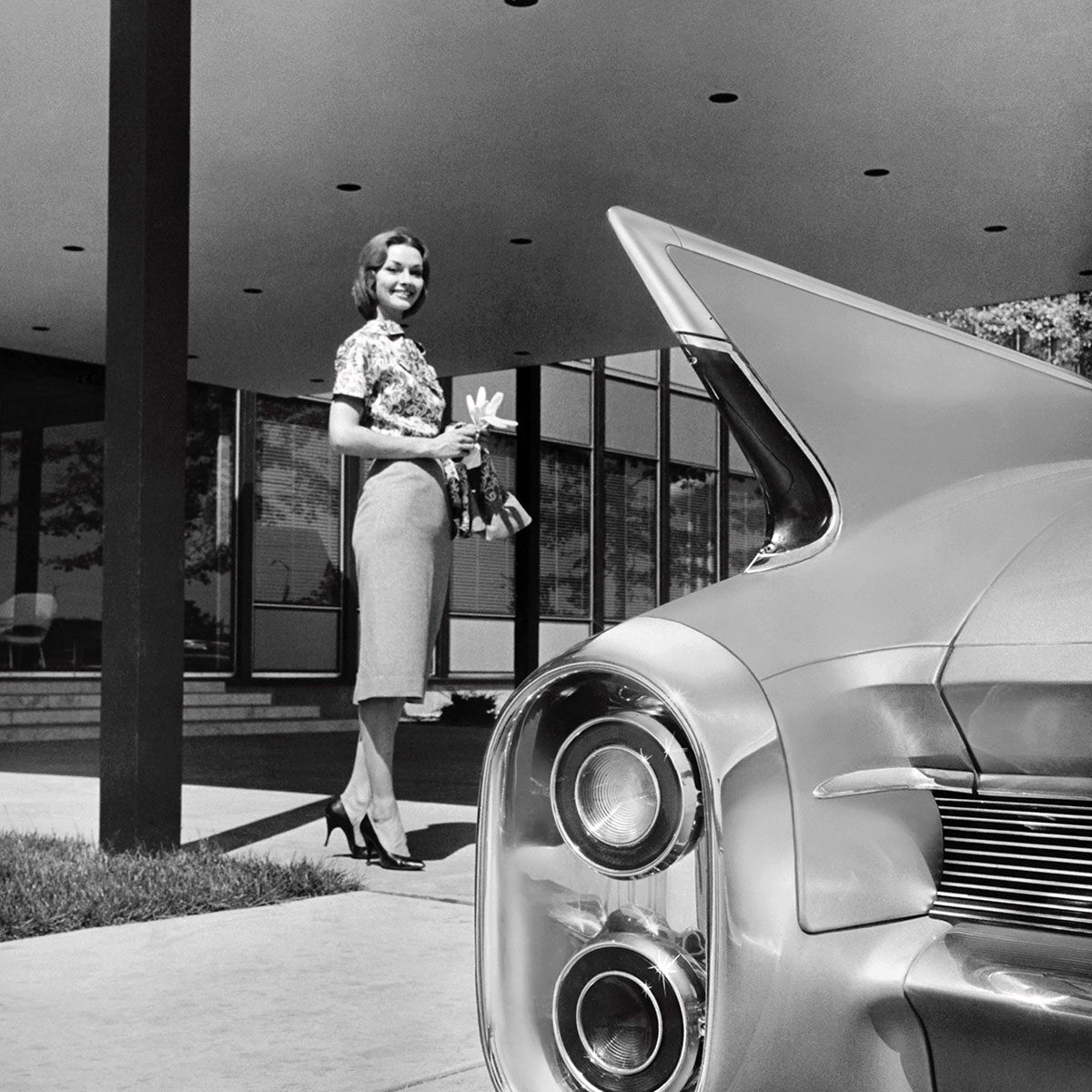Woman Smiling For Photo With Rear Fins Of The Cadillac Coupe In Frame