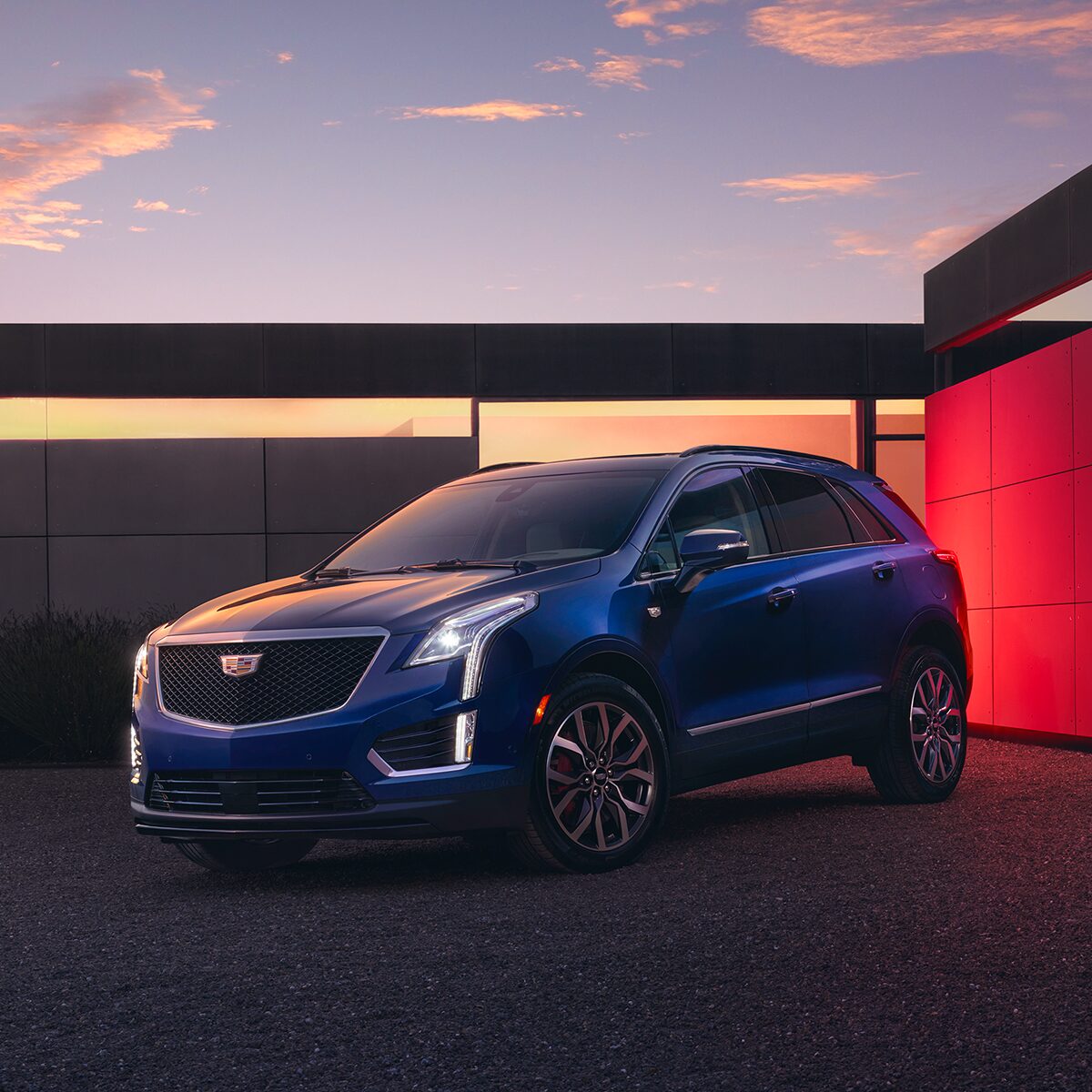 The Beautiful 2025 Cadillac XT5 Parked at Dusk in Front of Modern House With Lights On