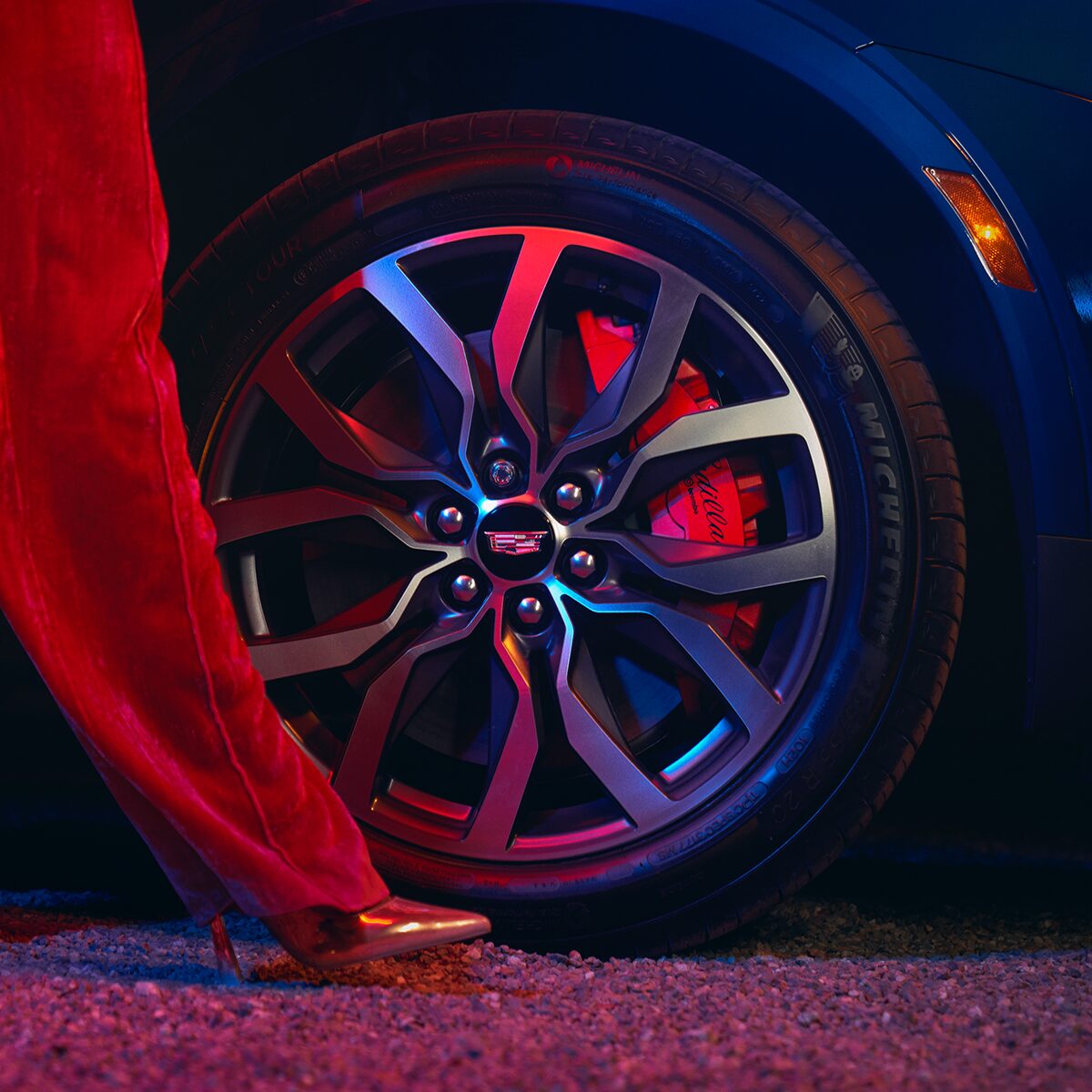 A Woman Walking Past The Tire of the Cadillac XT5 Exterior