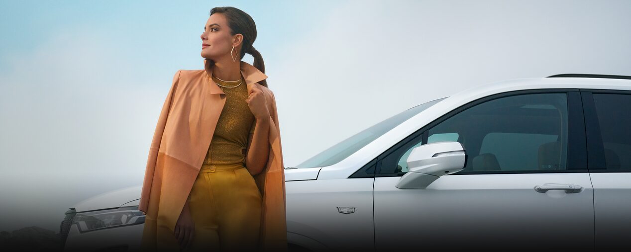 A Stylish Woman Stands Before the Driver's Side of a Cadillac XT6