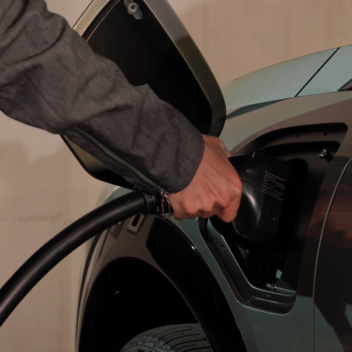 Close-up View of a Man Charging a 2025 Cadillac OPTIQ