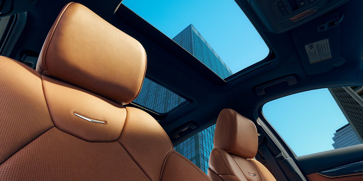 Sun Shining on 2025 Cadillac CT5 Crest on Front Leather Seats and View of Sun Roof