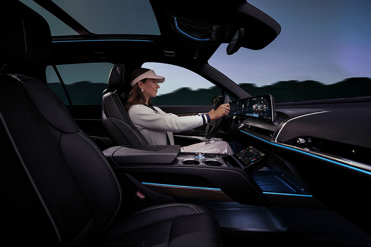 Passenger Side View of a Woman Driving the 2026 Cadillac VISTIQ Luxury Electric SUV