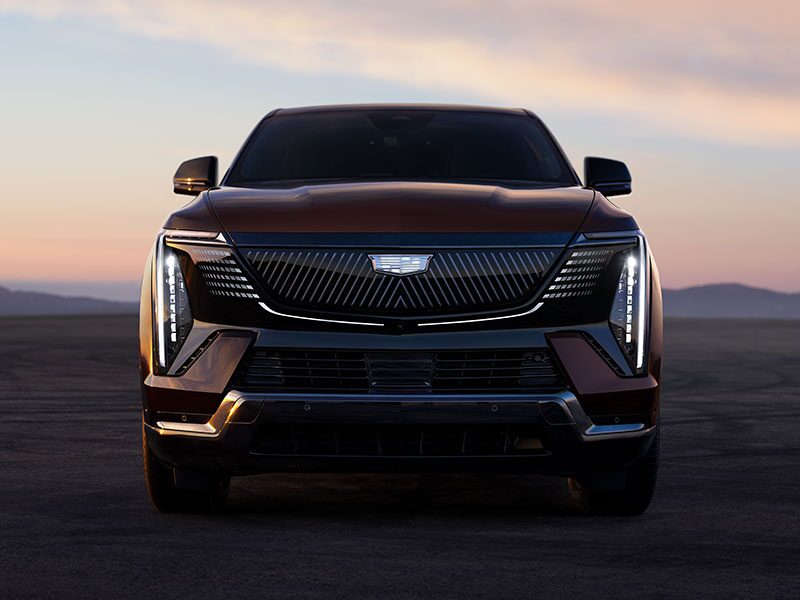 Front View of the 2026 ESCALADE IQ Parked in the Desert at Dusk with the Slimline LED Lights On