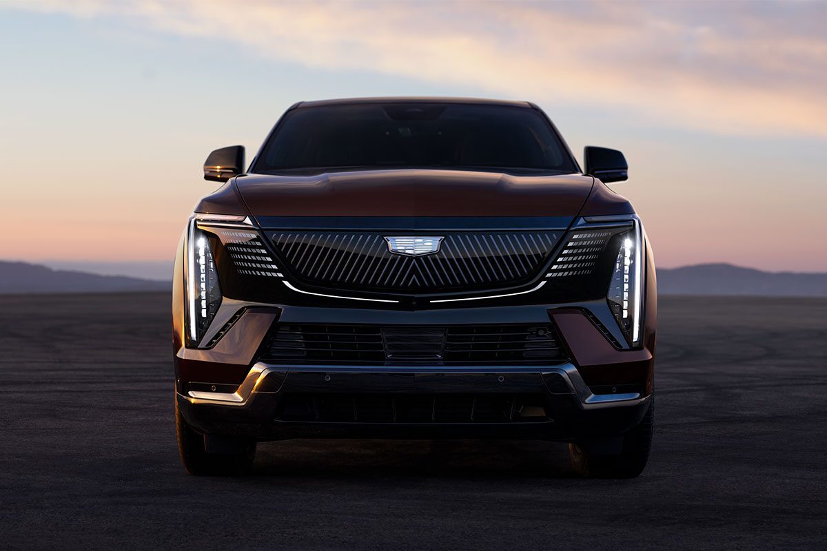 Front View of the 2026 ESCALADE IQ Parked in the Desert at Dusk with the Slimline LED Lights On