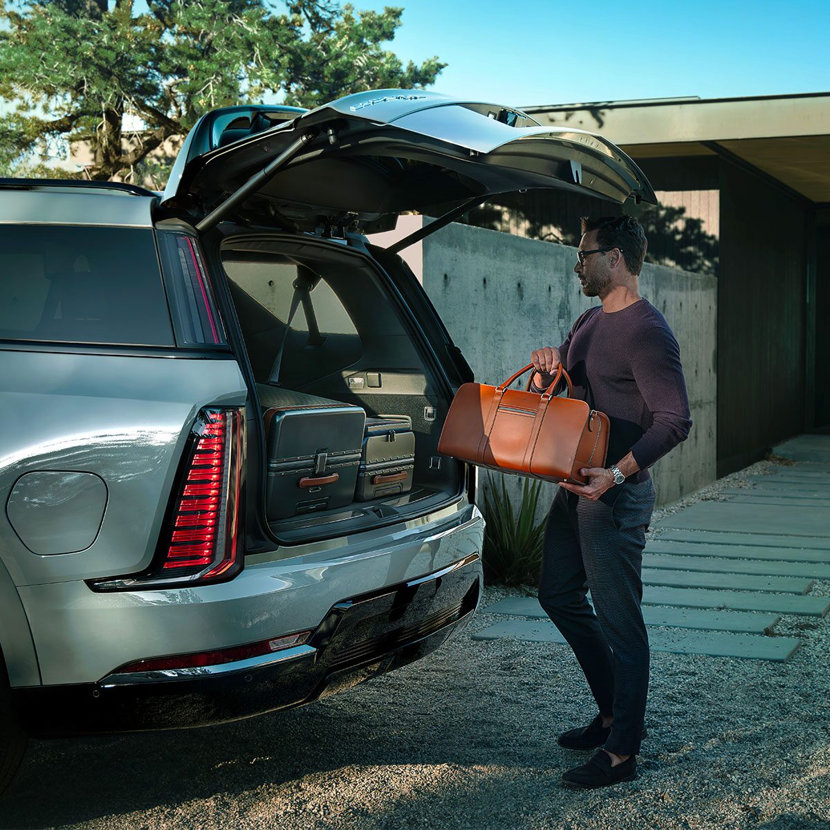 Close-up of a Man Loading Cargo Into the Spacious Trunk of a 2026 ESCALADE IQL