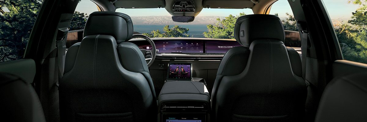 Third Row View of the 2026 ESCALADE IQL Interior and LED Screen While Outlooking the Mountains