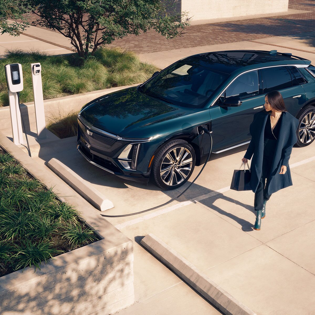 A Business Woman Walking Away From a Cadillac LYRIQ Charging at a Public Charger