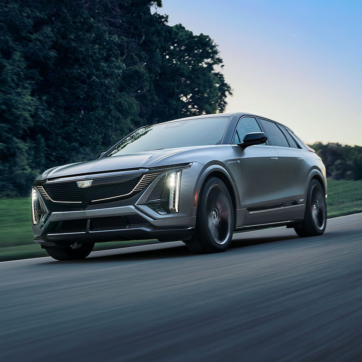 A Magnus Metal Cadillac LYRIQ Driving At Dusk