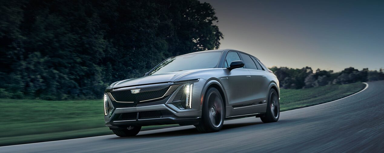 Three-quarter of a Magnus Metal Cadillac LYRIQ Driving At Dusk