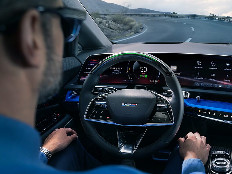 Front View of the 2026 OPTIQ-V Driving Through the Dusk Utilizing its Headlights