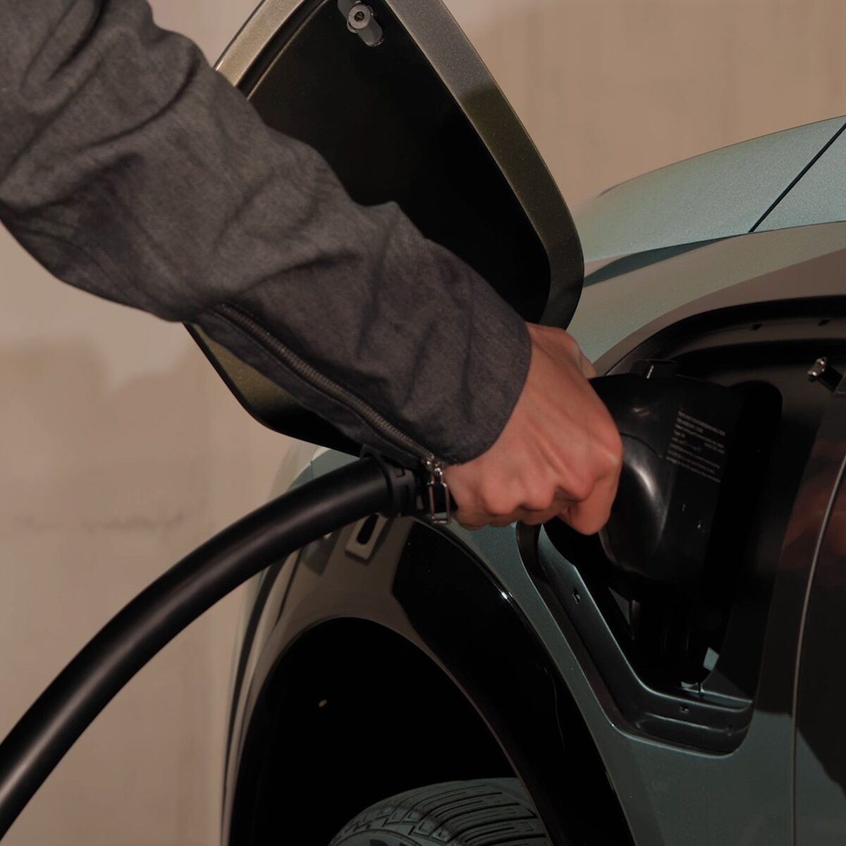 A Man Inserting the EV Charger in the 2026 OPTIQ-V Charging Port