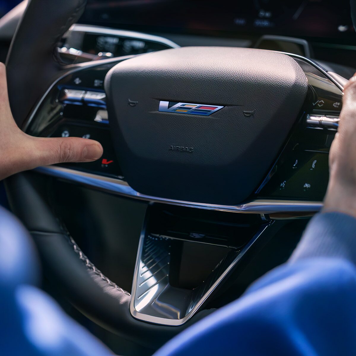 Close-up of a Man Driving and a Close-up of the V-Button on the 2026 OPTIQ-V Steering Wheel