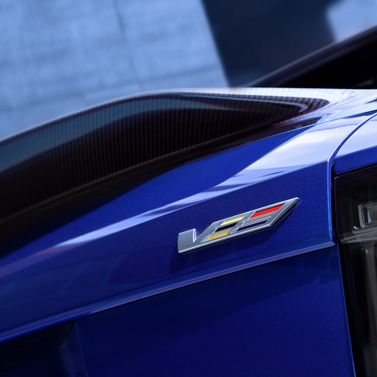 The V-Series Badge on the Rear End of a Blue 2026 OPTIQ-V