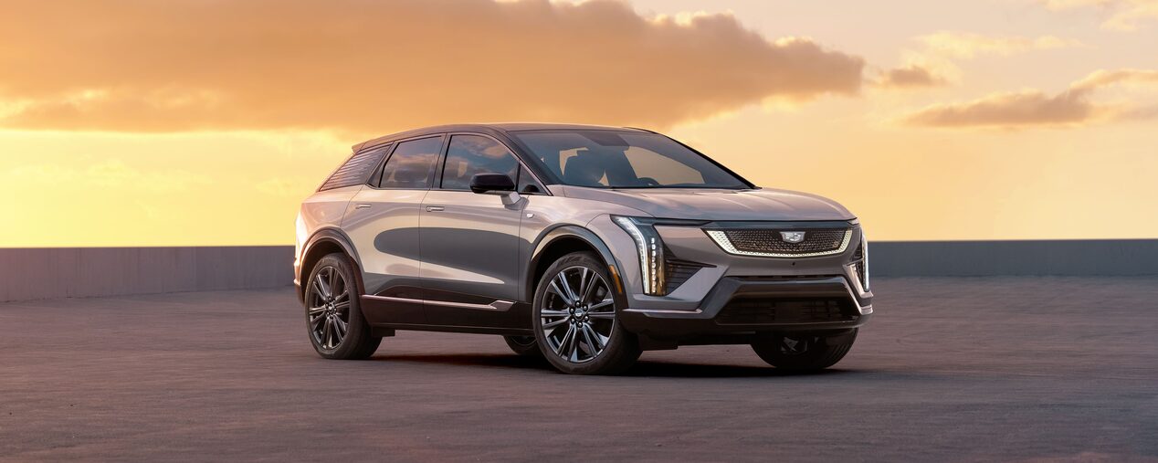 Three Quarters View of a Silver Cadillac OPTIQ Vehicle with Sunsetting Behind
