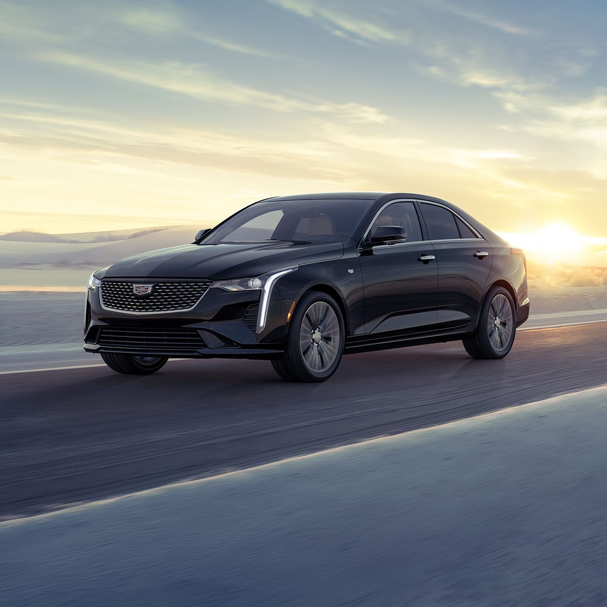 Three Quarters View of a 2026 CT4 Driving Through The Desert During a Sunrise