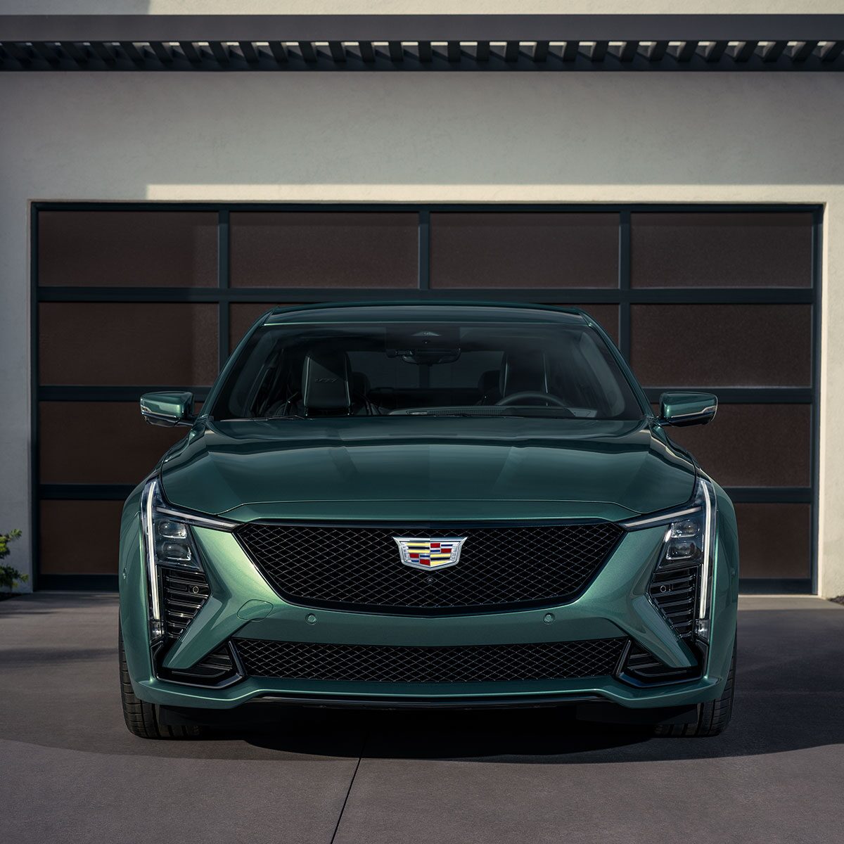 Front View of a Green Cadillac CT5-V Parked in the Driveway in Front of a Closed Garage