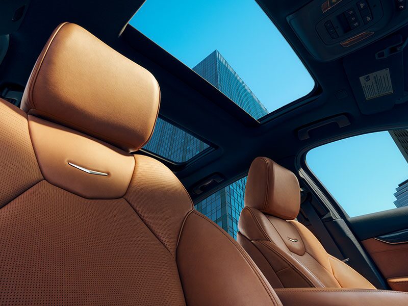 Sun Shining on 2026 Cadillac CT5 Crest on Front Leather Seats and View of Sun Roof