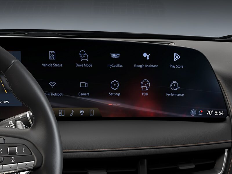 The 2026 Cadillac CT5 Steering Wheel and View of 33" Display Screen Outlooking Industrial Buildings