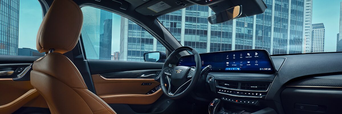 Driver's Side of the 2026 Cadillac CT5 Tan and Jet Black Accent Interior Outlooking an Industrial Building