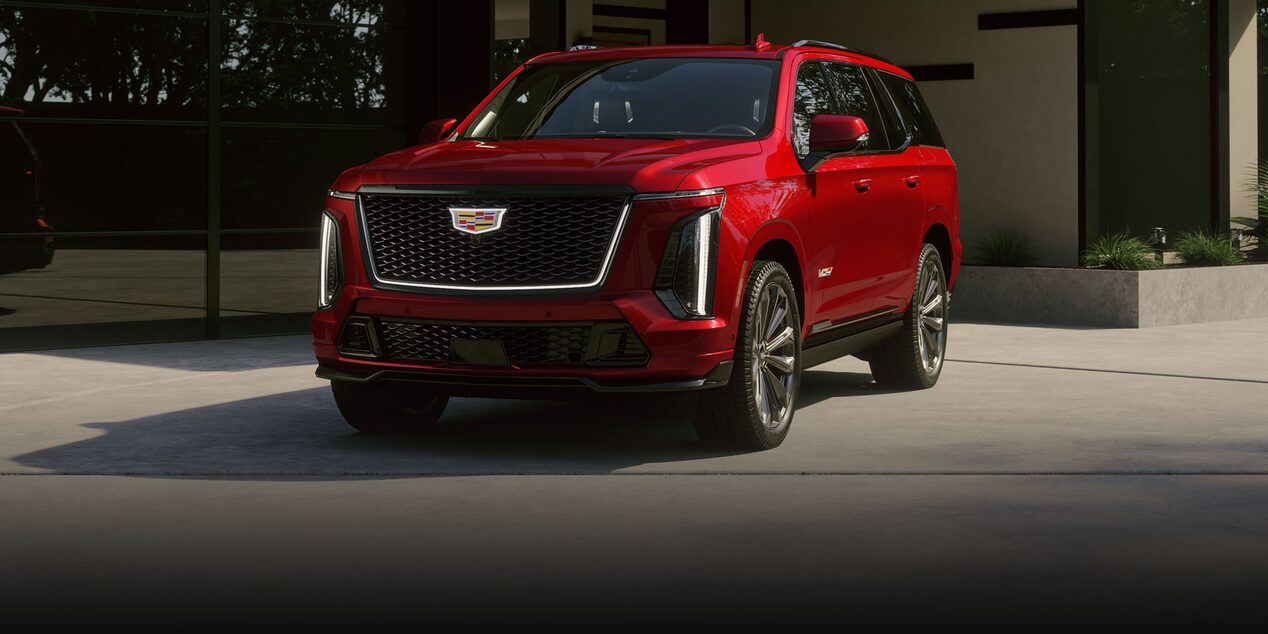A 2025 Red Cadillac Escalade-V Parked in Front of a Modern Home