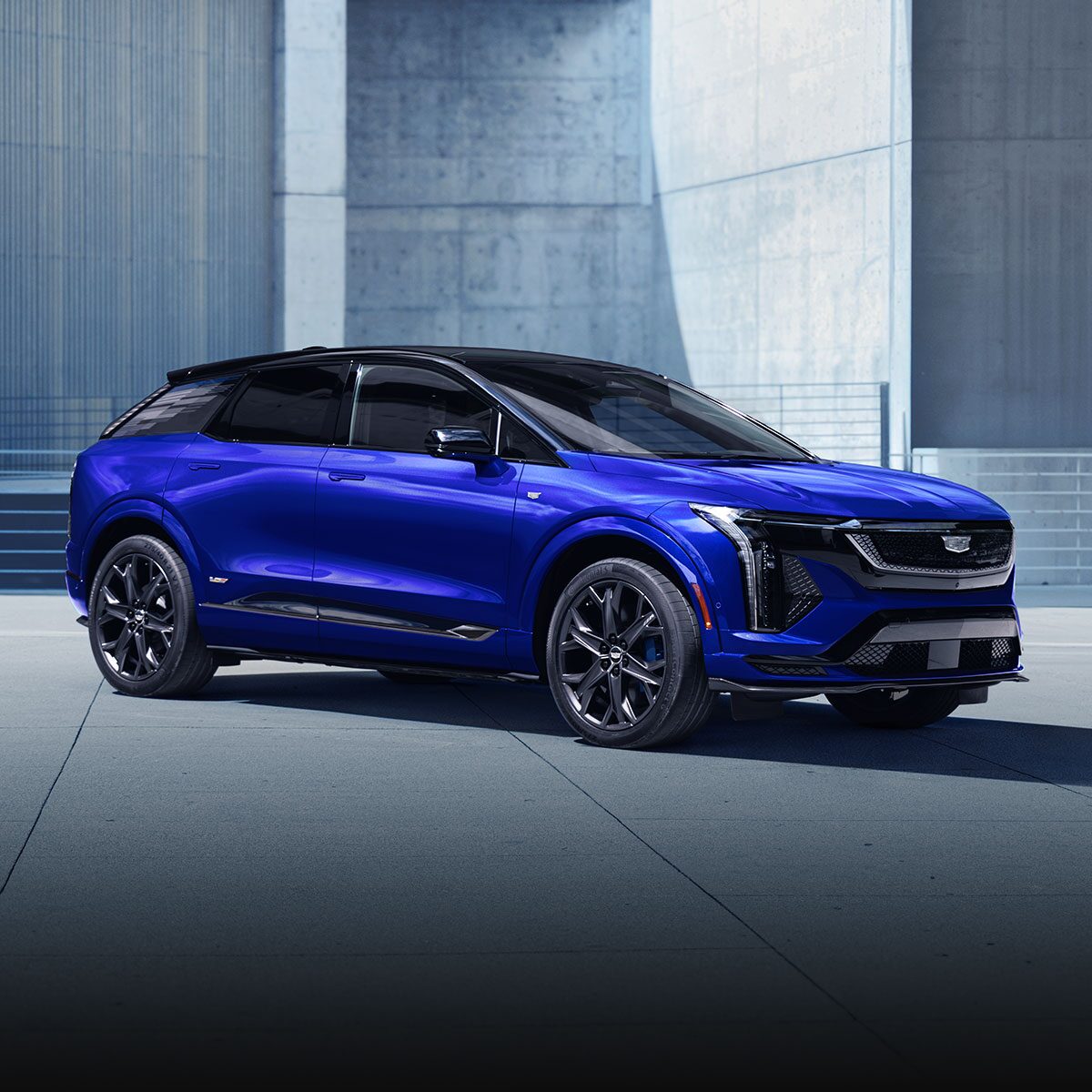 A Silver 2026 LYRIQ-V Driving Down a Highway with a Clear Blue Sky in the Background