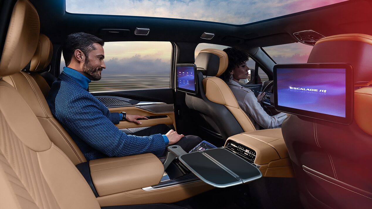 A Passenger in the Second Row of a 2025 ESCALADE IQ Enjoying the Rear Screen Entertainment