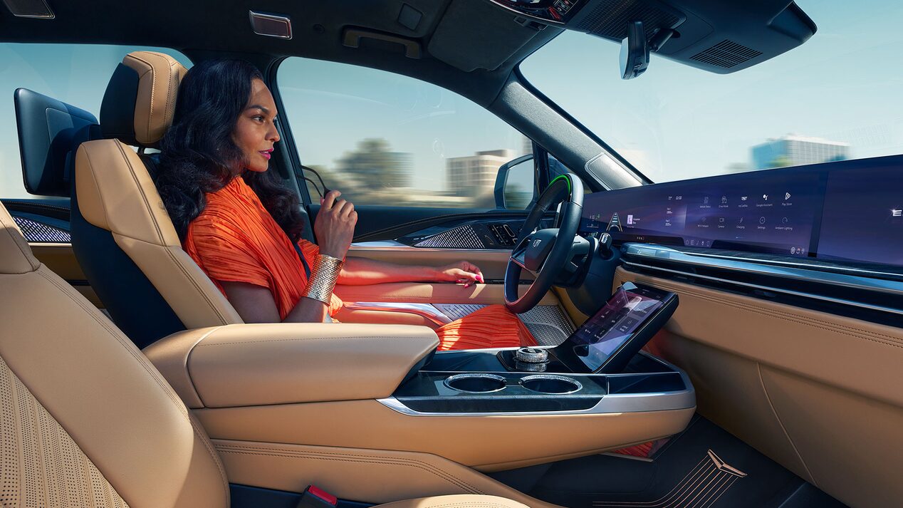 Woman Smiling While Driving the 2025 Cadillac ESCALADE IQ Using Super Cruise
