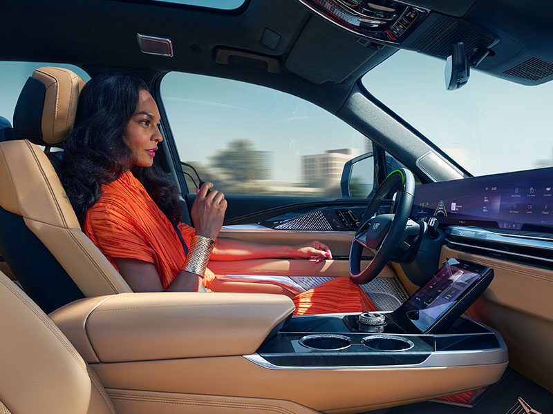 A Woman Driving Hands-free Utilizing Super Cruise While Driving the Cadillac ESCALADE IQ in the City