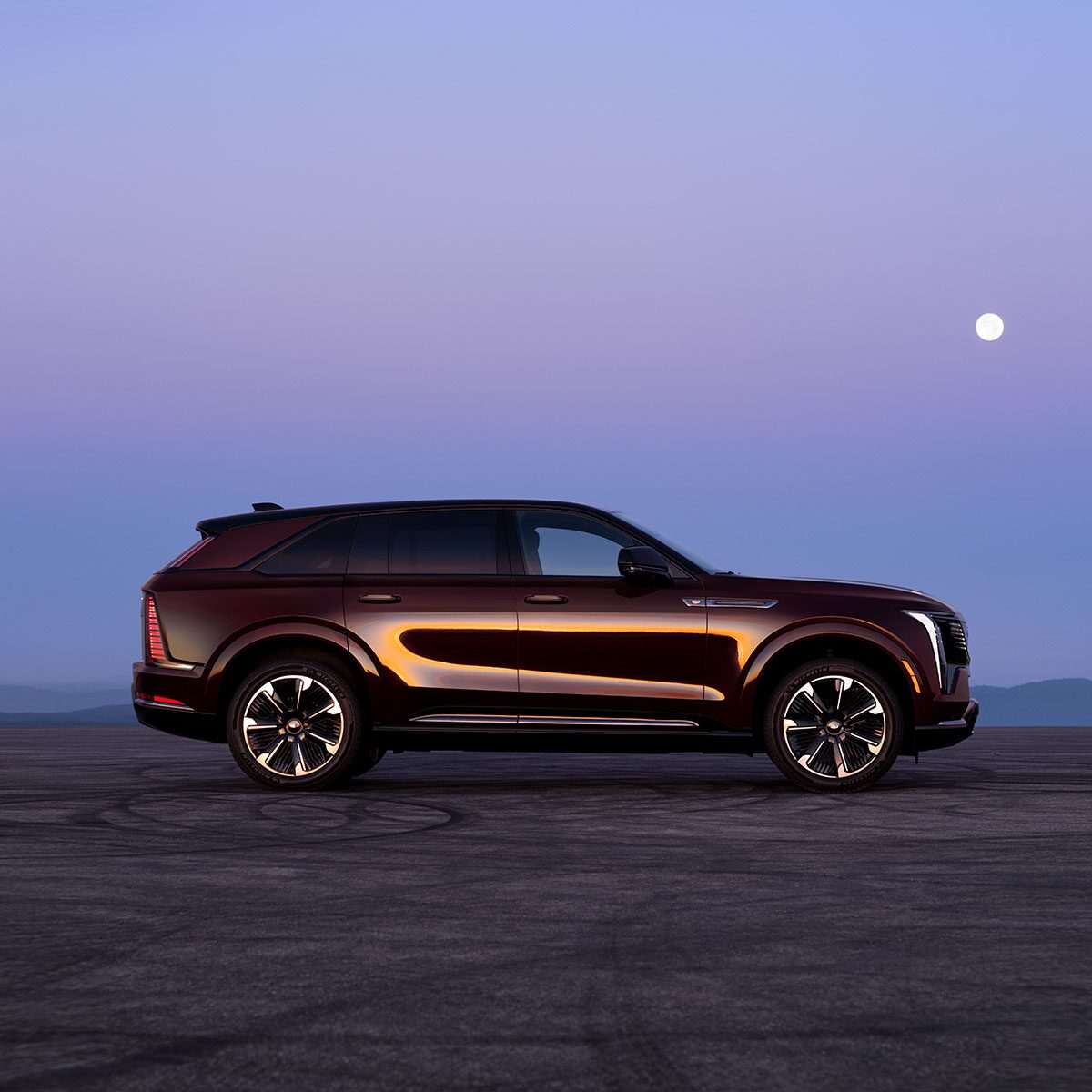 The Side Profile of the 2026 ESCALADE IQ Parked Under a Beautiful Moon in the Desert