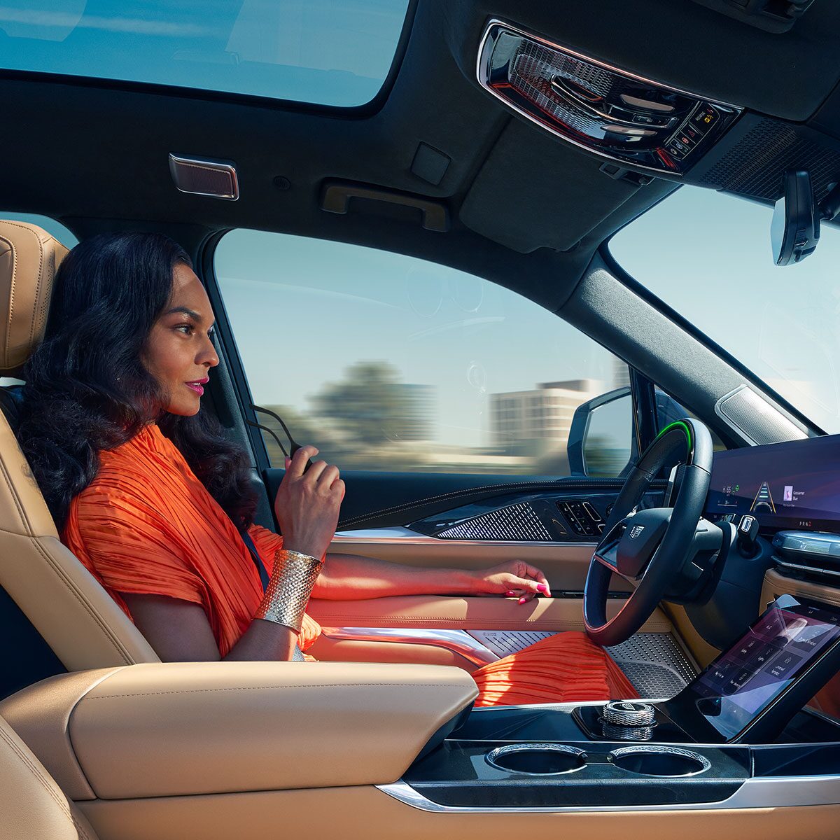 A Woman Driving Hands-free Utilizing Super Cruise While Driving the Cadillac ESCALADE IQ in the City