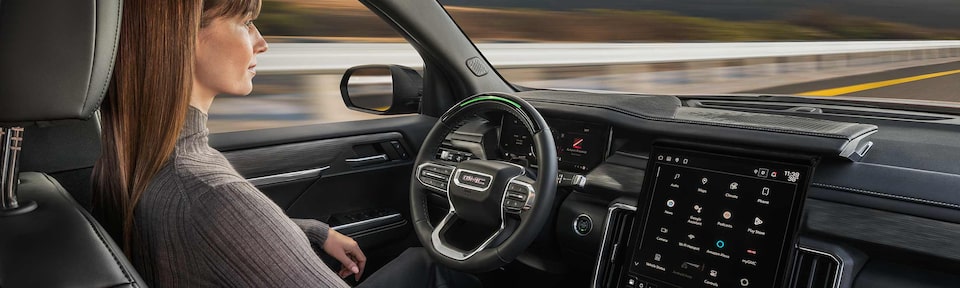 Profile View of a Woman Using Super Cruise Hands-Free Technology in Her GMC