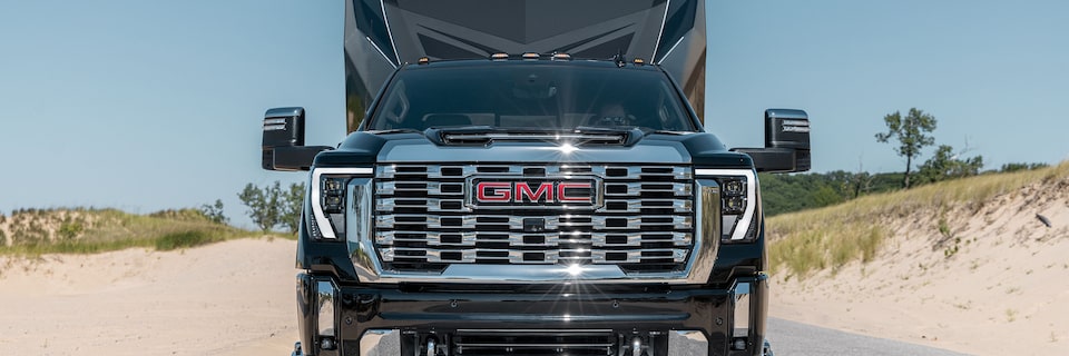 Front View of a Black GMC Pickup Truck Pulling a Black Trailer