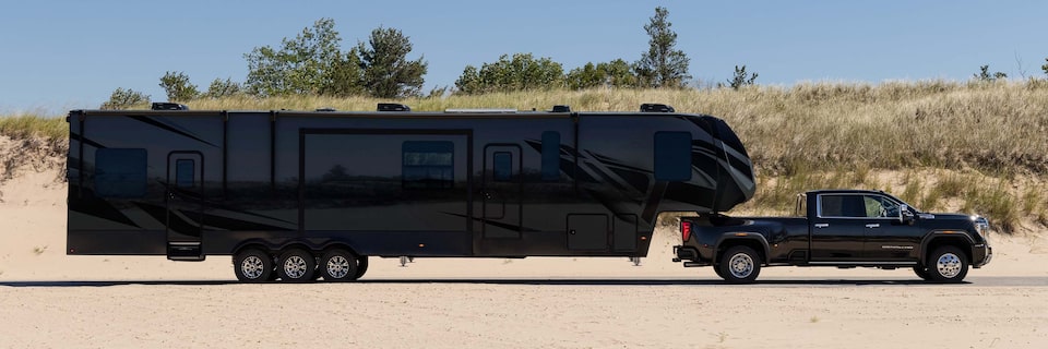 Slide Profile of a Large Black RV Attached to a Black GMC Pickup Truck