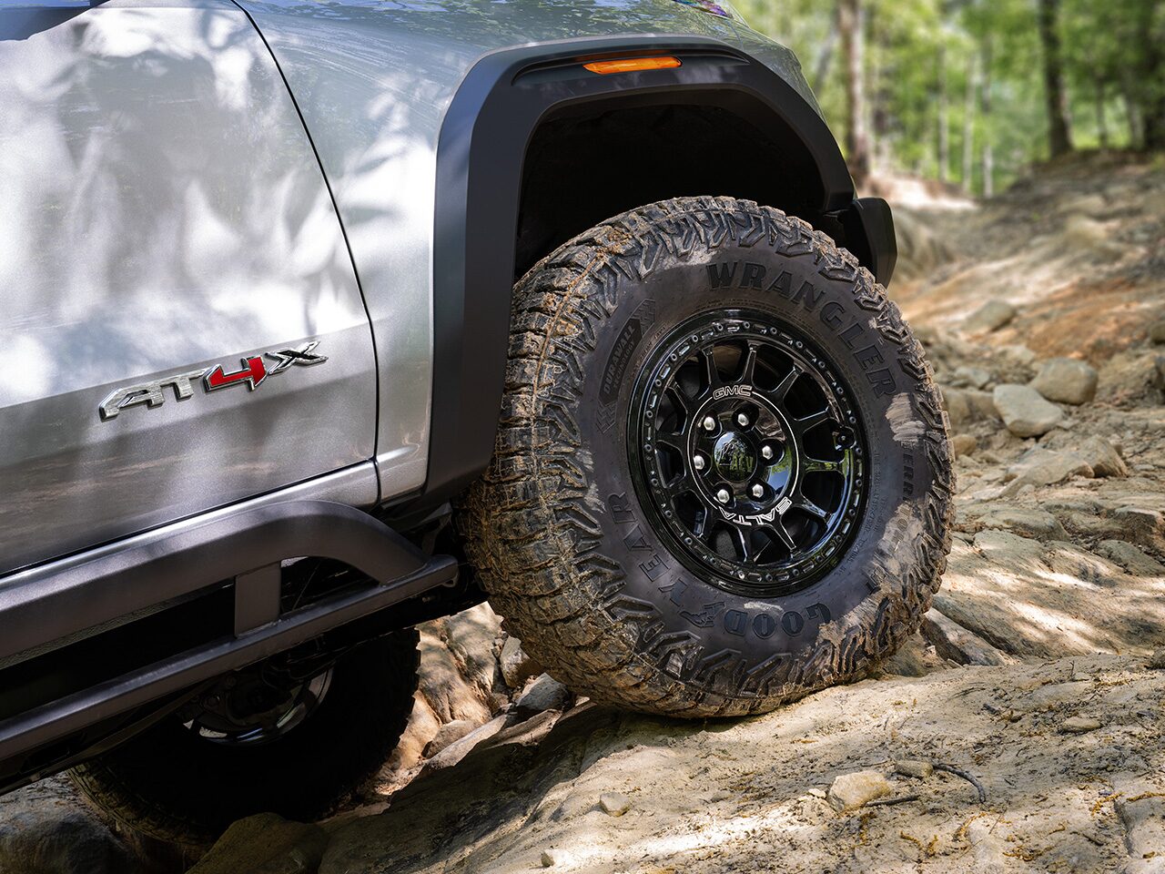 Close-up of the Tires on a GMC AT4X AEV Edition Truck Driving Over Rough Terrain