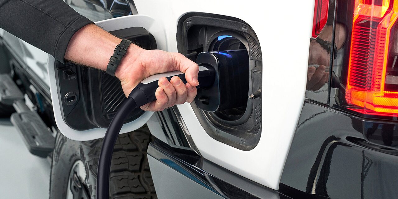 Close-up of a Man Charging his GMC EV at a Public EV Charging Station