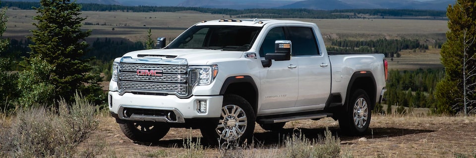 Front Three-Quarter View of a White GMC Sierra HD Heavy Duty Truck Parked in a Field