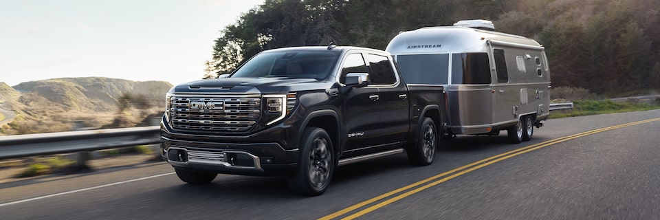 GMC Sierra Denali Truck Towing an Airstream RV Down the Road