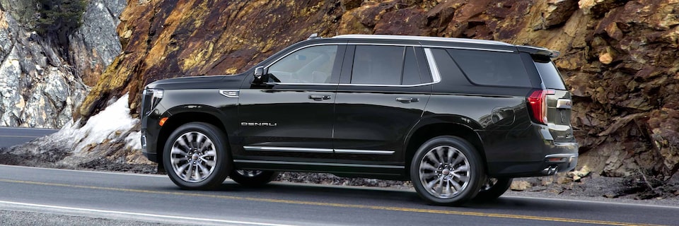 Side Profile View of a GMC Yukon Denali Driving up a Mountain Road