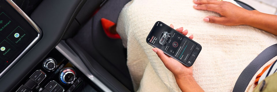 Over Head View of a Woman Sitting in the Passenger Seat of a GMC Vehicle Using her Smartphone